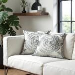 Modern embroidered cotton pillow covers with gray medallion pattern on white sofa with black window frames