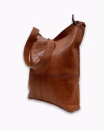 Side view of model with leather hobo handbag in elegant setting