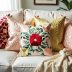 Embroidered cotton pillow covers with floral design layered with peach and yellow decorative cushions