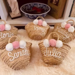 Set of personalized mini straw bags with names and pink pom poms