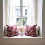 Red floral cushions styled in bright window seat