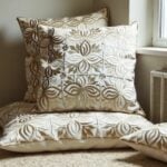 Beige leather pillow covers with floral cutwork displayed on chair near window showing textured appliqué patterns