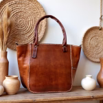 Styled product shot of brown leather tote with decorative elements