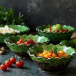 Green Tamegroute ceramic bowls with cherry tomatoes on dark surface highlighting artisan craftsmanship