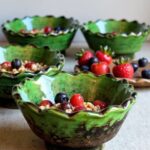 Three Tamegroute ceramic bowls with berries and granola showing food-safe glossy green glaze