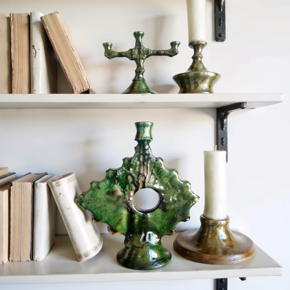 Antique-style ceramic candleholder displayed on bookshelf