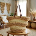 Side view of striped straw bag showing X-stitched leather handle attachment on woven raffia