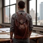 Man wearing woven leather backpack in brown with basket-weave texture in modern office setting