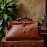 Brown leather duffle bag resting on tan armchair, handcrafted cognac leather weekend bag interior view