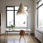 Handwoven palm leaf pendant light with natural fiber texture above modern desk workspace