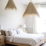 Pair of handwoven palm leaf pendant lights illuminating modern kitchen island with white countertops