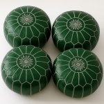 Four emerald green leather floor ottomans with white star embroidery and hand-stitched geometric seams in Moroccan style