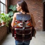 Woman wearing dark brown leather kilim backpack with geometric handwoven patterns outdoors against brick wall
