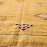 Detailed macro view of cactus silk yellow rug fibers showing natural texture and geometric weaving patterns