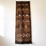 Detailed view of brown cactus silk runner showing intricate diamond and geometric patterns with fringe tassels