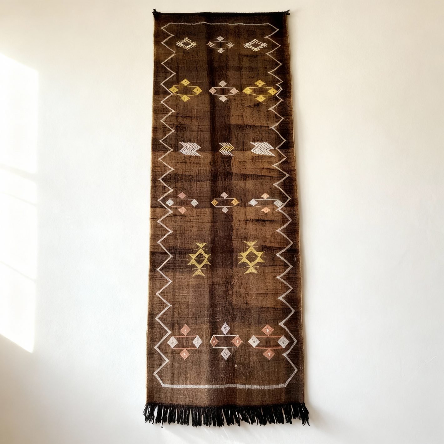Detailed view of brown cactus silk runner showing intricate diamond and geometric patterns with fringe tassels Moroccan runner rug with brown cactus silk, tribal geometric embroidery and black fringe