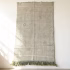 Green cactus silk rug with minimalist design displayed as wall hanging showing natural texture and fringe