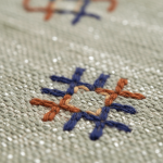 Close-up of green Moroccan rug showing handwoven embroidered geometric motifs detail