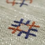 Close-up of green cactus silk rug revealing blue, orange, and cream geometric Berber motifs