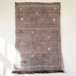 Purple cactus silk rug with geometric diamond patterns displayed as wall hanging showing traditional fringe tassels