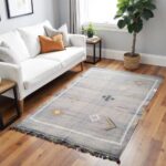 Gray cactus rug with geometric designs in bright living room with white sofa and orange accent pillow