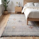 Moroccan cactus rug beside wooden bed frame in minimalist bedroom with natural light and neutral decor