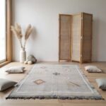 Handwoven cactus rug in meditation space with floor cushions, pampas grass, and wooden room divider