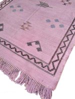 Pink Moroccan rug corner detail showing handwoven cactus silk texture, fringe, and tribal motifs