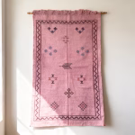 Handwoven moroccan sabra rug wall hanging showing traditional pink cactus silk with border design