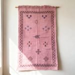 Handwoven moroccan sabra rug wall hanging showing traditional pink cactus silk with border design