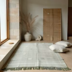 Handwoven green cactus silk rug in modern minimalist bedroom with natural lighting and wooden furniture