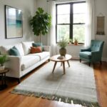 Green Moroccan rug in living room with white sofa, teal chair, and mid-century decor