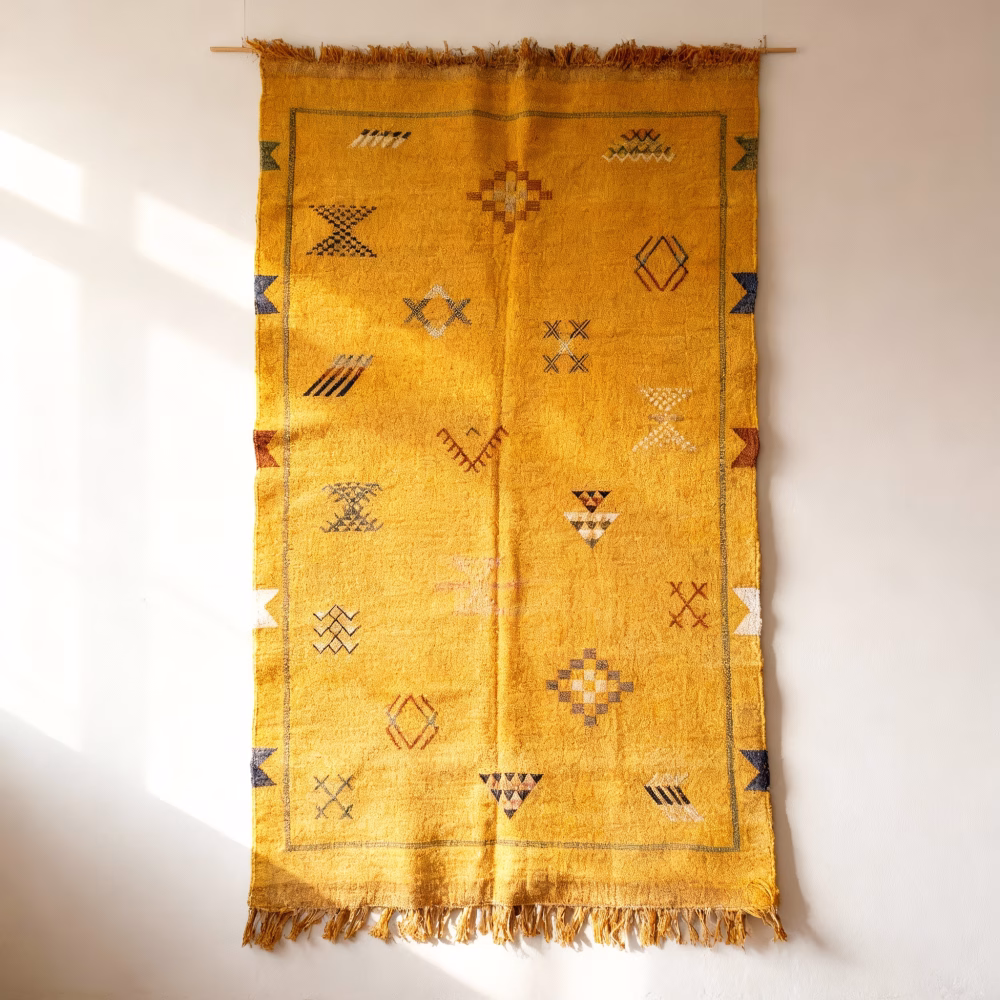 Yellow cactus silk rug wall hanging display showcasing traditional Moroccan tribal patterns and fringe tassels