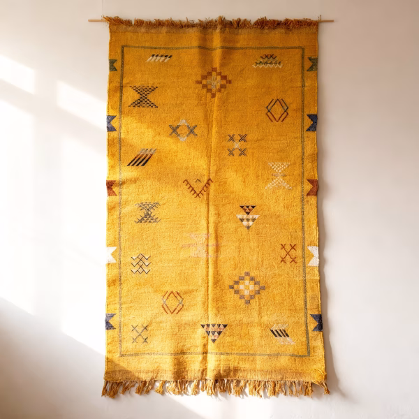 Yellow cactus silk rug wall hanging display showcasing traditional Moroccan tribal patterns and fringe tassels