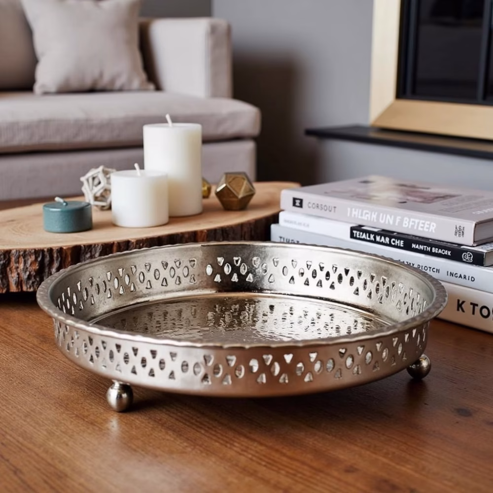 Handcrafted Moroccan silver circle tray with feet styled on wooden coffee table with candles
