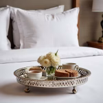 silver hammered circle tray with feet displaying coffee and flowers by bedside