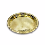 Angled studio shot of a polished brass circle tray showing its textured surface.