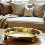 Silver circle tray on a wooden living room coffee table in a cozy vignette