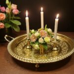 Gold-plated round serving tray with hand-engraved geometric center used as candle and floral centerpiece