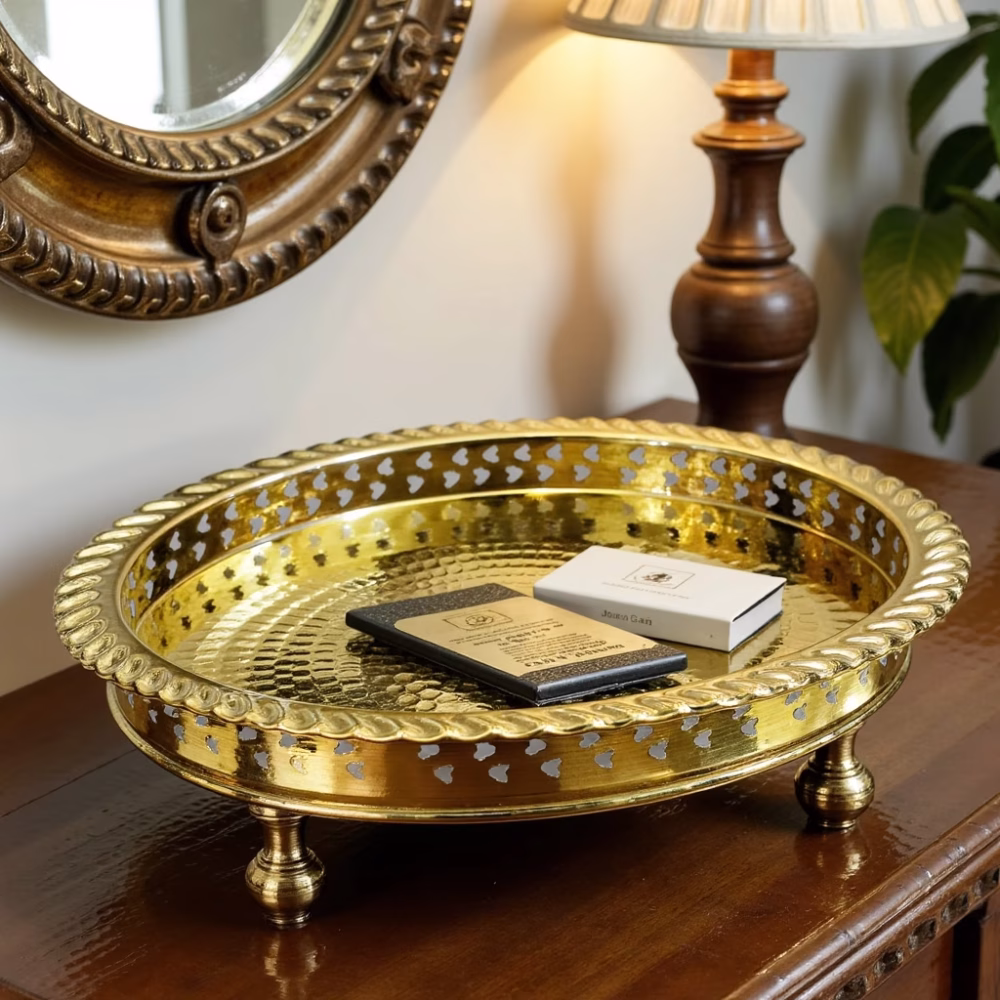 Entryway console styled with notebooks resting on a lustrous brass circle tray under a mirror.
