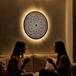 Decorative round brass wall light with intricate pierced design creating warm atmosphere in home