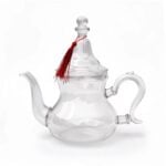 Handblown borosilicate glass teapot with tassel and crimson silk knot featuring a clear gooseneck spout
