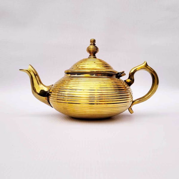 Profile view of gold modern design teapot
