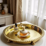 Perfume bottles arranged on a golden circle tray by a sunlit bedroom window.