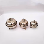 Three matching silver-plated sugar bowl containers with ornate lids