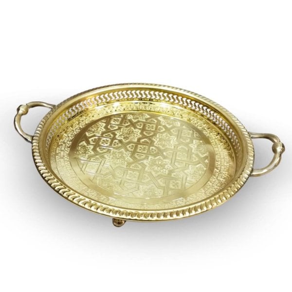 Overhead view golden brass serving tray with intricate engraved geometric pattern