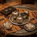Four-piece silver tea container set including three covered bowls and one rectangular embossed tray