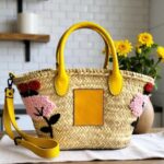 Handwoven raffia straw crossbody bag with diagonal plait weave and yellow leather contrast stitching