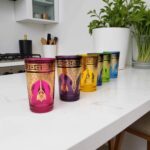 Set of six colorful golden henna tea glasses with hand-painted arabesque patterns on marble