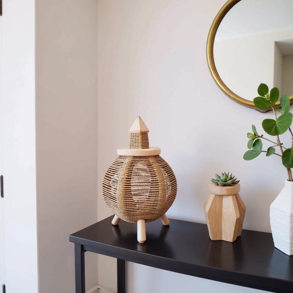 Moroccan straw table lamp on black accent table with minimalist decor